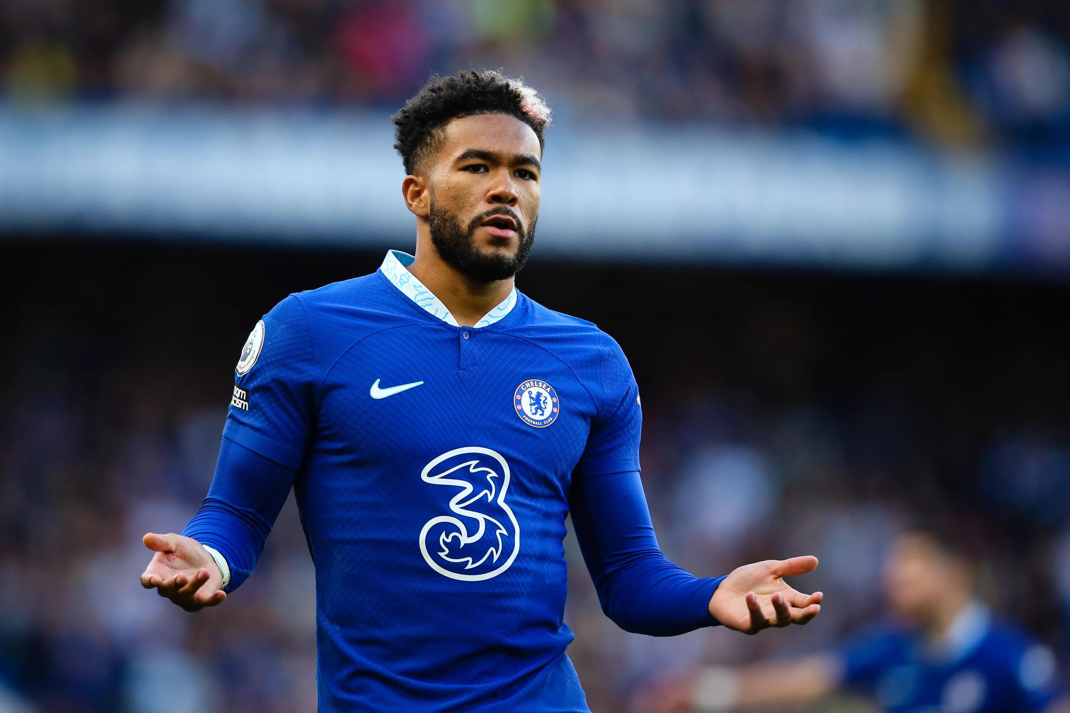 Рис Джеймс в домашней форме Chelsea 2022/23 с раскрытыми ладонями на фоне трибун.